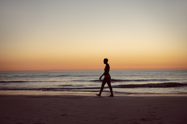 Foto gratuita mujer en bikini caminando por la playa