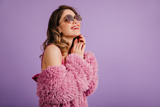 Mujer blanca dichosa posando en gafas de sol