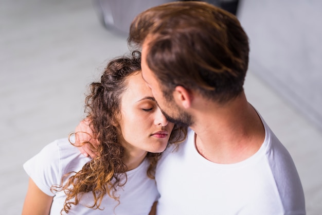 Foto gratuita mujer en blanco sosteniendo la cabeza en el hombro del hombre