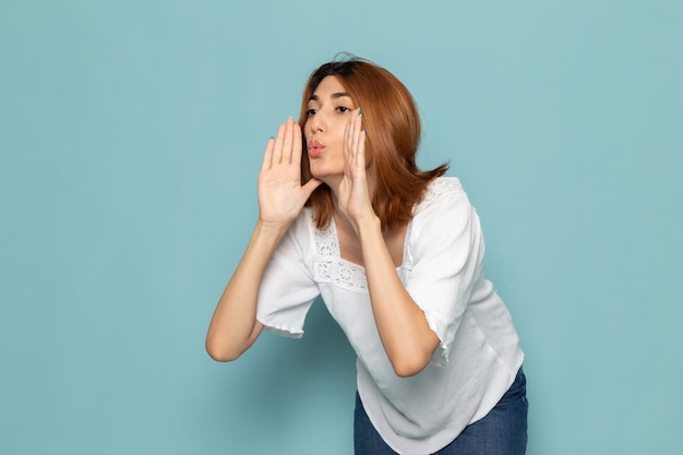 mujer en blusa blanca y pantalones vaqueros azules posando y gritando