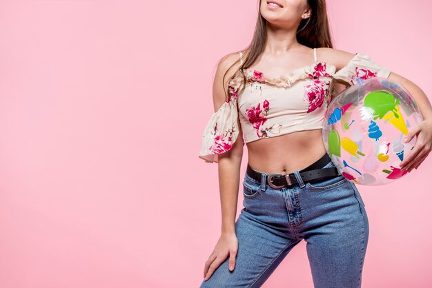 Mujer en blusa colorida con pelota de playa