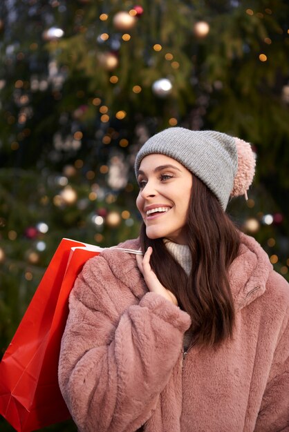 Mujer con bolsa de compras en el mercado de Navidad