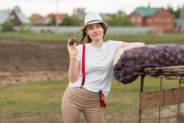 Foto gratuita mujer con una bolsa de frutos en una granja