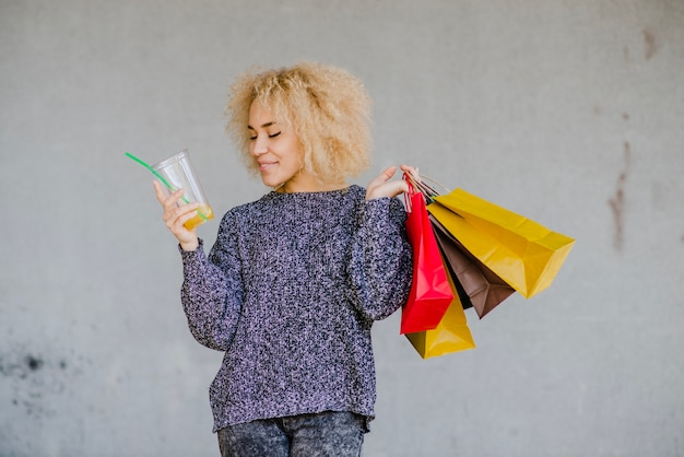 Mujer con bolsas y bebida