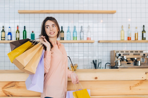 Foto gratuita mujer con bolsas de papel cerca del mostrador