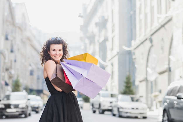 Foto gratuita mujer con bolsas de papel de colores en la calle