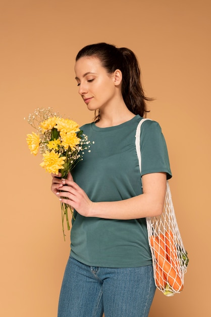 Foto gratuita mujer con bolso de tortuga y ramo de flores