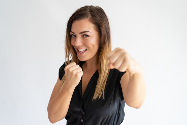 Mujer bonita alegre que se coloca en actitud del boxeo