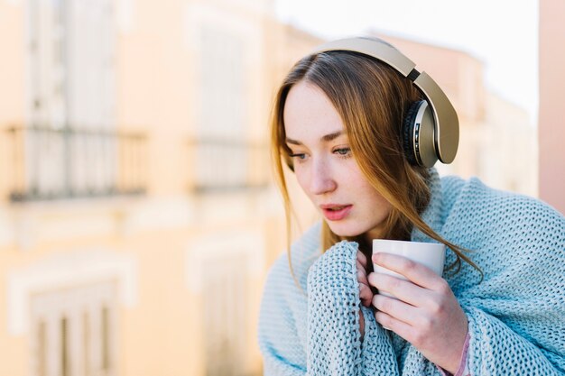 Mujer bonita en auriculares mirando hacia abajo