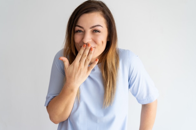 Foto gratuita mujer bonita avergonzada cubriendo boca y riendo