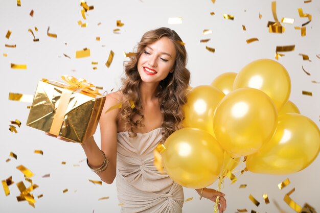 Mujer bonita celebrando el año nuevo con globos