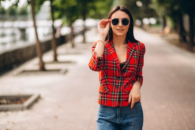 Mujer bonita en chaqueta roja afuera en el parque