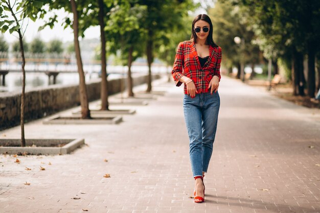 Mujer bonita en chaqueta roja afuera en el parque