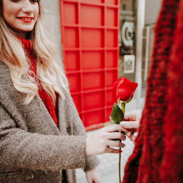 Mujer bonita dando rosa al hombre