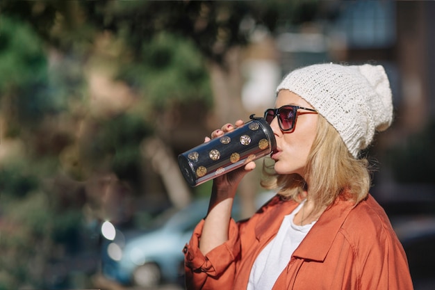 Mujer bonita disfrutando de bebidas en la calle