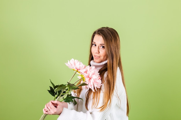 Mujer bonita europea en suéter blanco casual aislado, mirada romántica con ramo de flores rosadas con sonrisa