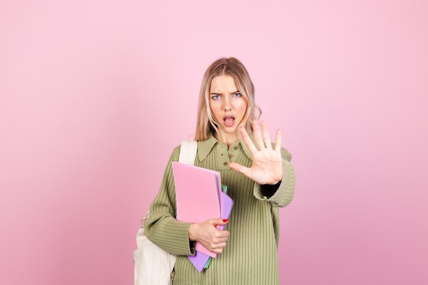 Mujer bonita europea en suéter casual en pared rosa