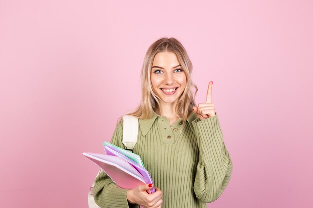 Mujer bonita europea en suéter casual en pared rosa