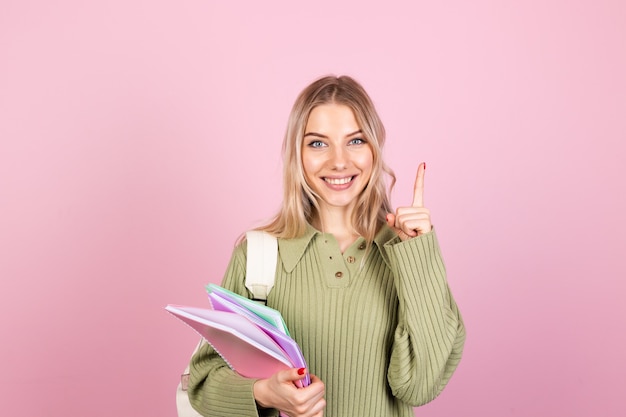 Mujer bonita europea en suéter casual en pared rosa