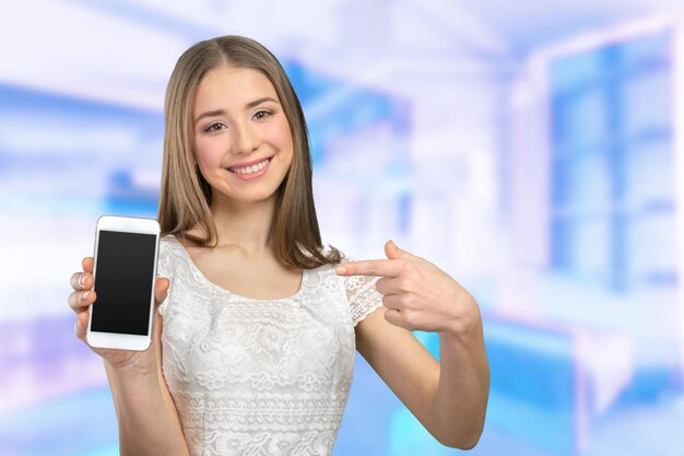 Mujer bonita feliz mostrando una pantalla de teléfono inteligente en blanco