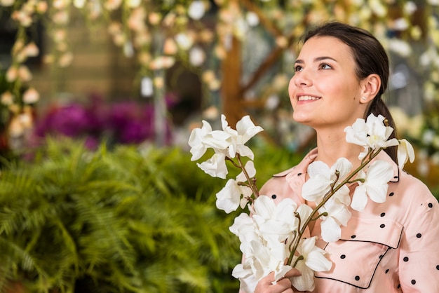 Foto gratuita mujer bonita con flores blancas en las manos