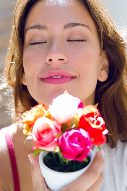 Mujer bonita con flores en casa