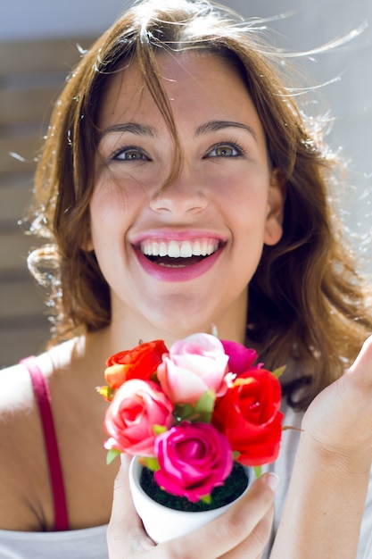 Mujer bonita con flores en casa