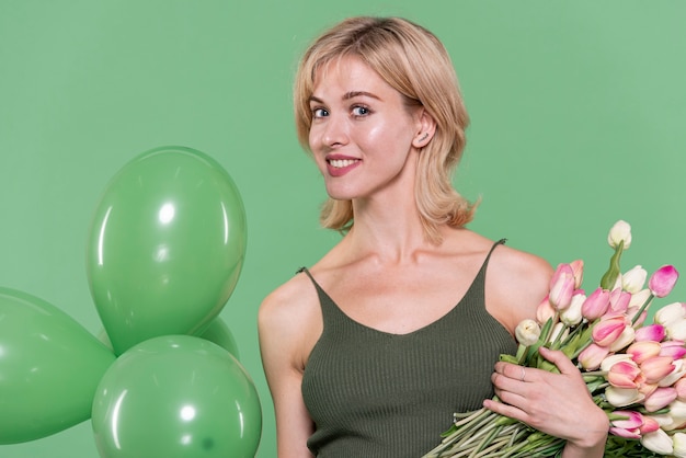 Foto gratuita mujer bonita con flores y globos