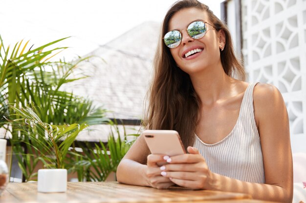 Mujer bonita con gafas de sol en café