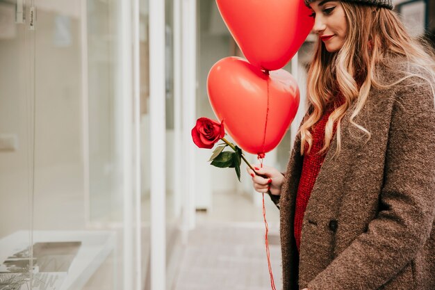 Mujer bonita con globos y rosa