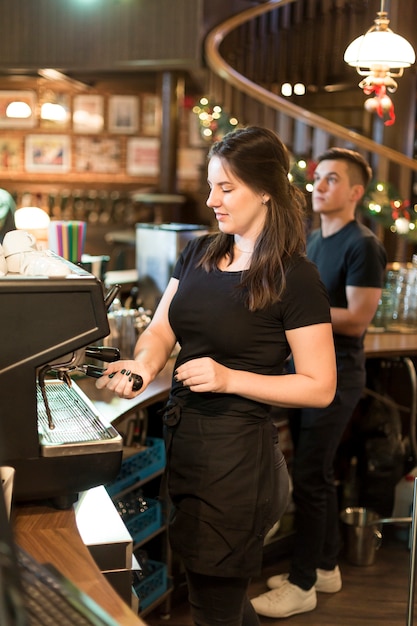 Mujer bonita haciendo café en café