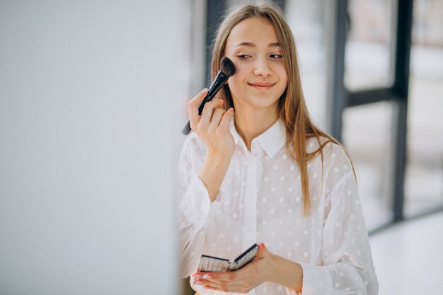 Mujer bonita haciendo maquillaje en casa