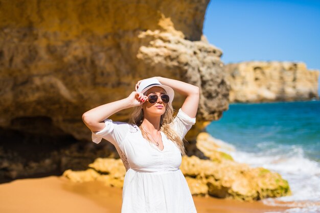 Mujer bonita joven caminando por la playa en verano