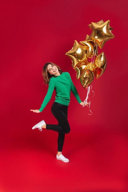 Mujer bonita joven feliz que sostiene los globos.