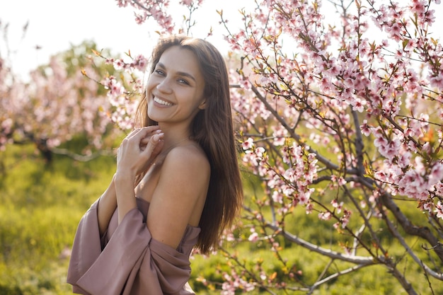 mujer bonita joven en jardín floreciente