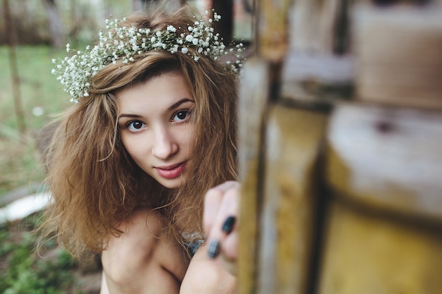 Mujer bonita joven llevando una corona de flores