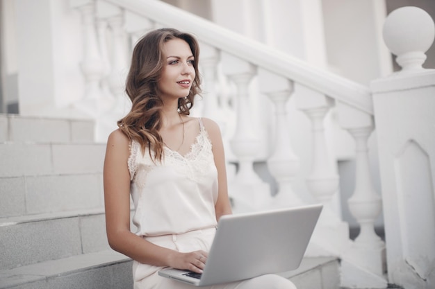 mujer bonita joven que trabaja en la computadora portátil