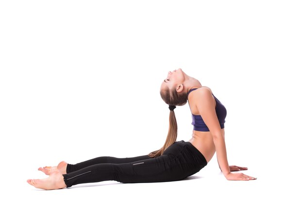 Mujer bonita joven en ropa blanca activa hacer ejercicios de yoga sobre fondo blanco.