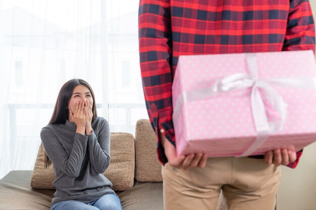 La mujer bonita joven se siente emocionante para recibir el regalo del novio