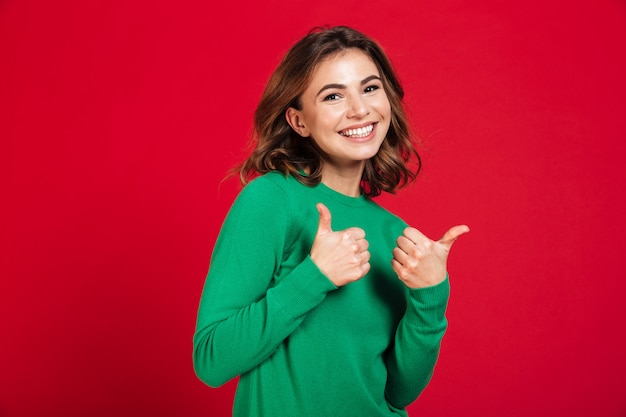 Mujer bonita joven sonriente que se coloca aislada