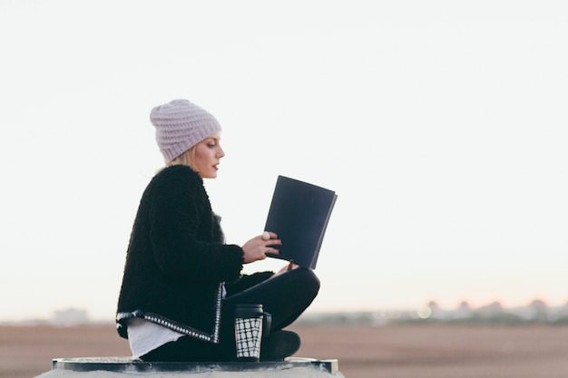 Mujer bonita leyendo el libro en la naturaleza