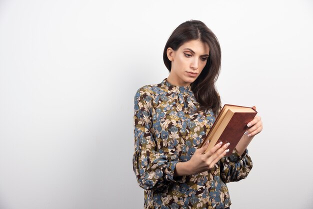 Mujer bonita leyendo un nombre del libro.