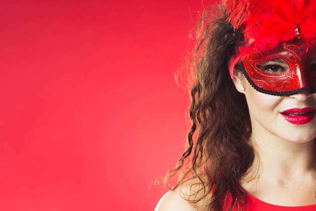 Mujer bonita en máscara de carnaval rojo