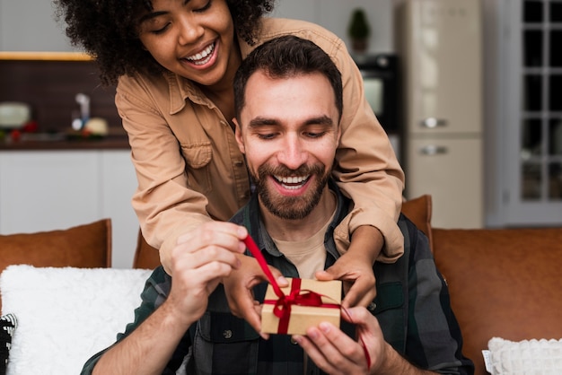 Mujer bonita mujer ofreciendo un regalo a su novio