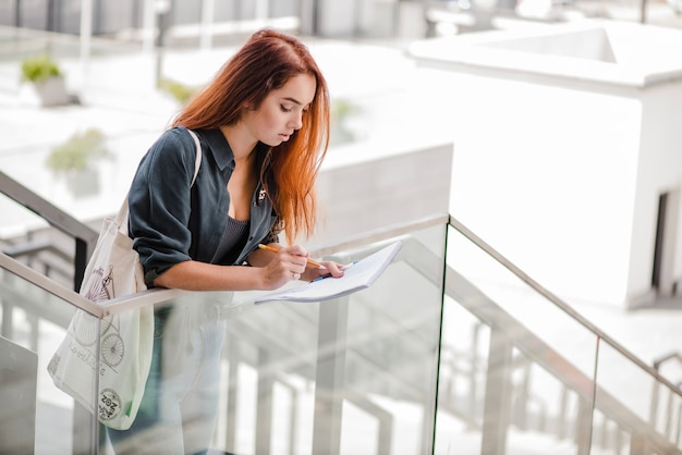 Mujer bonita con papeles en las escaleras solo