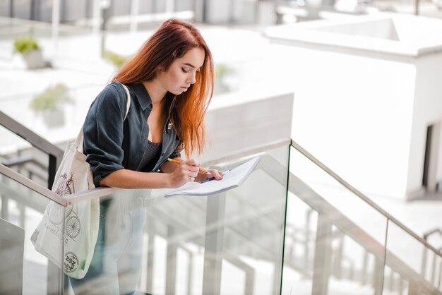 Mujer bonita con papeles en las escaleras solo