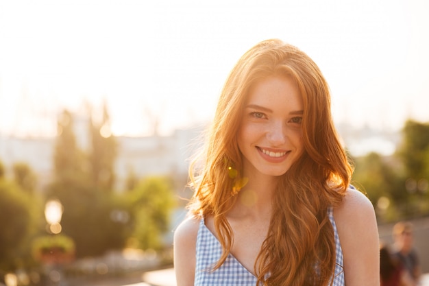 Mujer bonita pelirroja feliz con el pelo largo