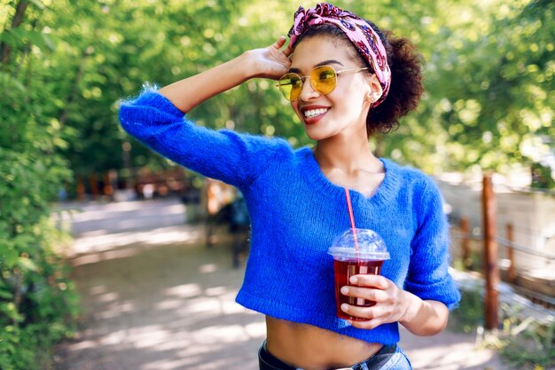 Mujer bonita con piel morena disfrutando de los días de verano en el parque.