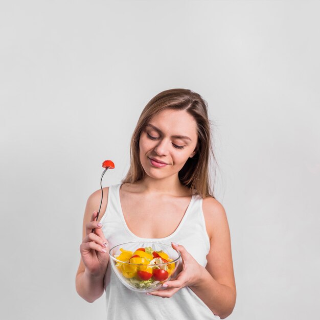 Mujer bonita con plato de ensalada y tenedor