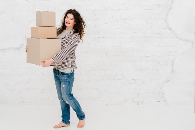 Mujer bonita posando con cajas de cartón